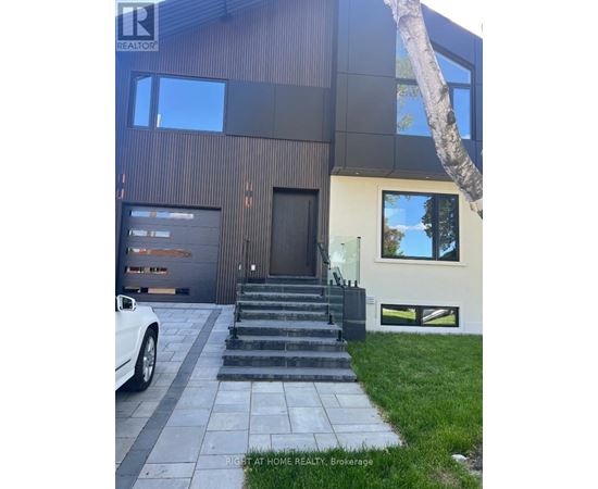 A modern house with a white car parked in front.