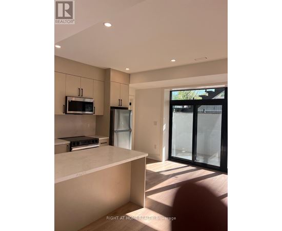 A modern kitchen with a white countertop and a microwave above it.