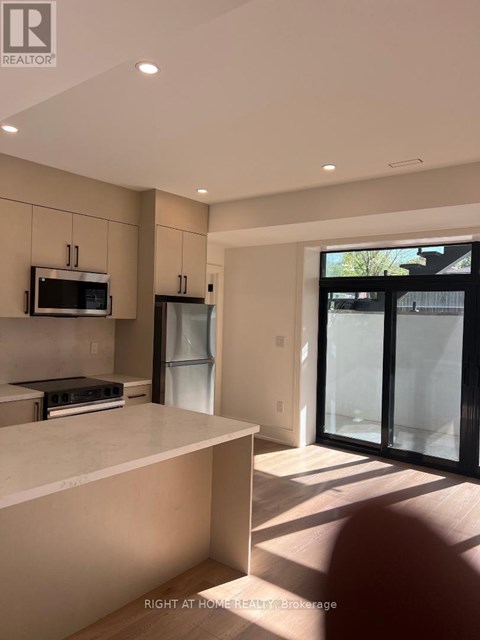 A modern kitchen with a white countertop and a microwave above it.