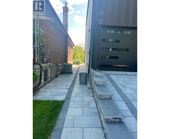 A stone pathway leads to a garage.