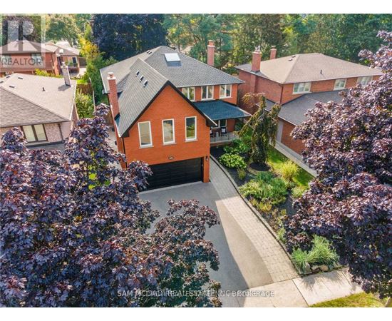 A house with a red roof is surrounded by greenery.