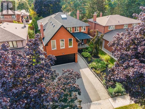 A house with a red roof is surrounded by greenery.