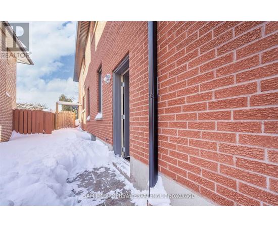 A red brick wall with a black pipe running along it.