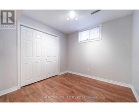 A bedroom with wood flooring and a white door.
