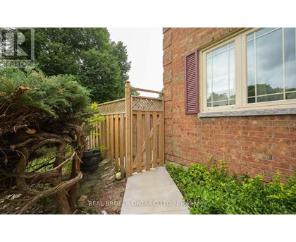 A wooden fence and gate in front of a brick building.
