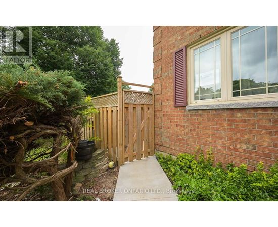 A wooden fence and gate in front of a brick building.