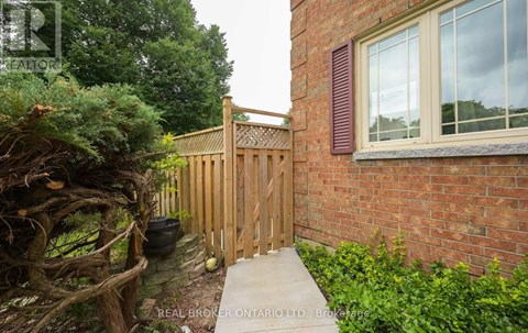 A wooden fence and gate in front of a brick building.