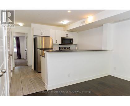 A kitchen with white cabinets and a stainless steel refrigerator.