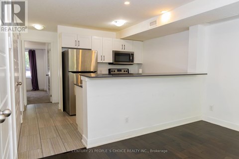 A kitchen with white cabinets and a stainless steel refrigerator.