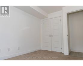 A bedroom with a white door and carpeted floor.