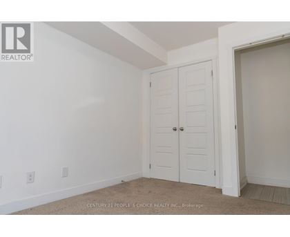 A bedroom with a white door and carpeted floor.