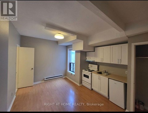 A kitchen with white cabinets and a stove top oven.