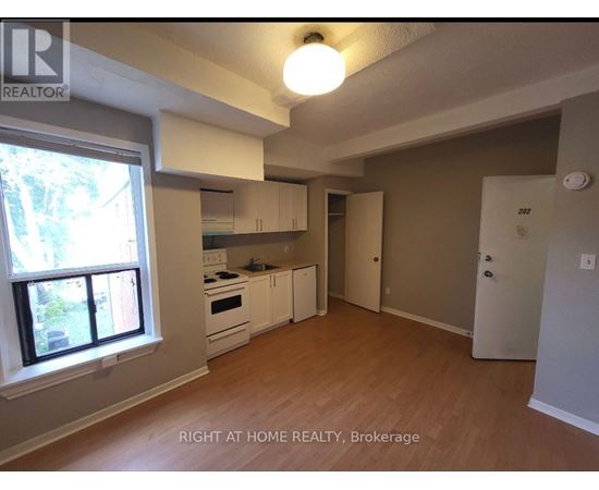 A kitchen with white appliances and wooden floors.