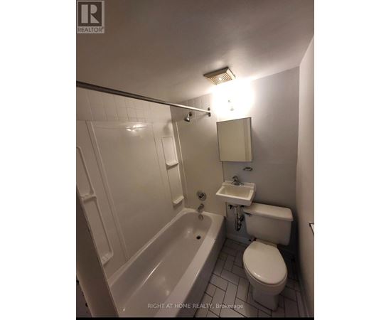 A white bathroom with a toilet, sink, and bathtub.