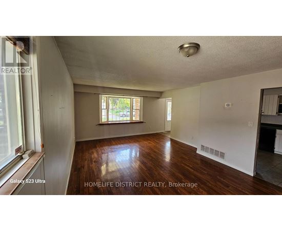 A room with wooden floors and a window with blinds.