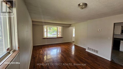 A room with wooden floors and a window with blinds.