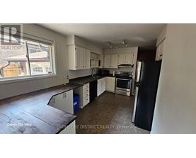 A kitchen with black and white appliances and cabinets.