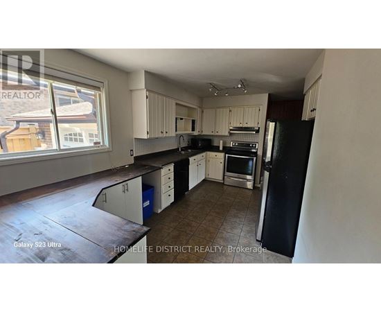A kitchen with black and white appliances and cabinets.