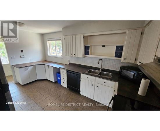 A kitchen with white cabinets and a black countertop.