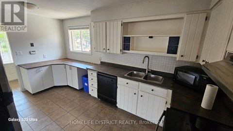 A kitchen with white cabinets and a black countertop.