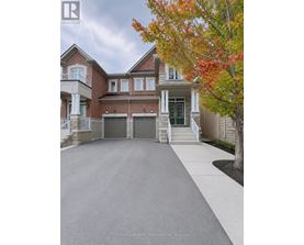 A large, well-maintained house with a driveway in front.