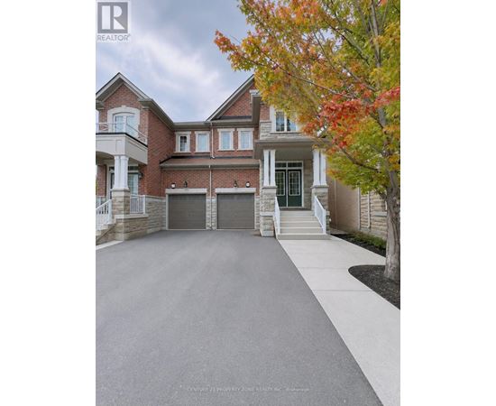 A large, well-maintained house with a driveway in front.