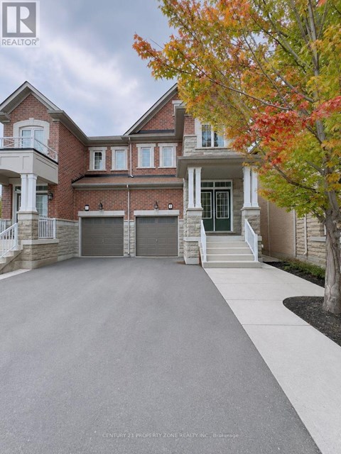 A large, well-maintained house with a driveway in front.