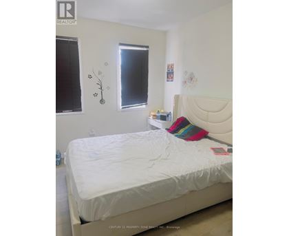 A white bed with a white headboard and a white mattress in a bedroom.