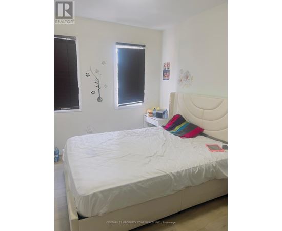 A white bed with a white headboard and a white mattress in a bedroom.