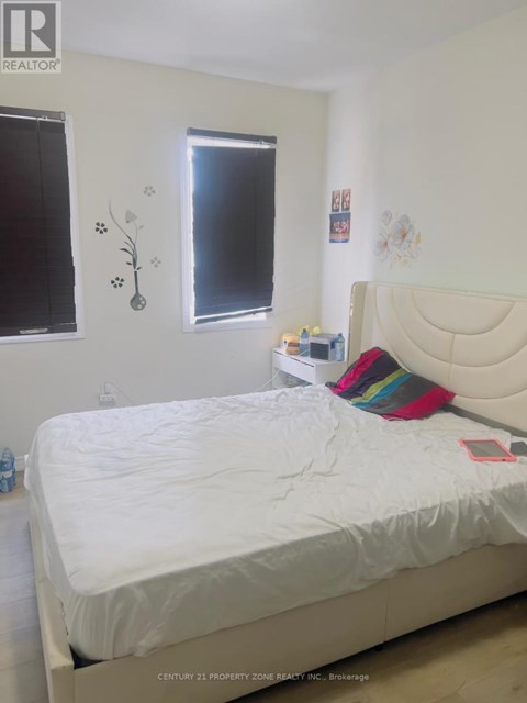 A white bed with a white headboard and a white mattress in a bedroom.