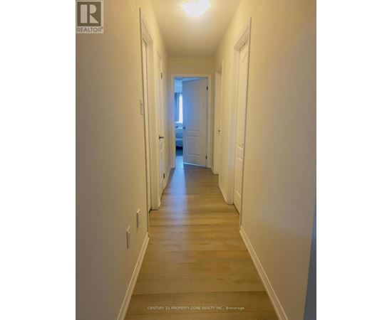 A long hallway with white walls and wood floors.