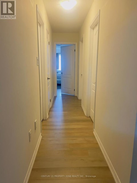 A long hallway with white walls and wood floors.