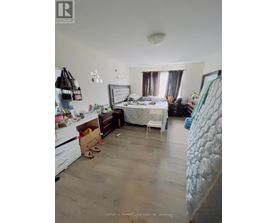 A bedroom with a bed, dresser, and chair.
