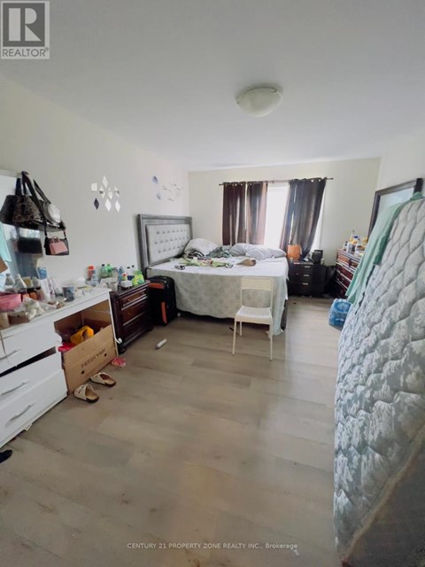 A bedroom with a bed, dresser, and chair.