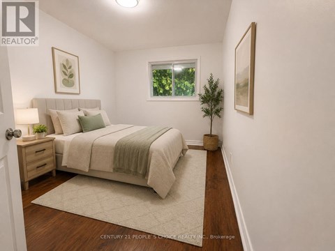 A bedroom with a bed, nightstand, and a plant.