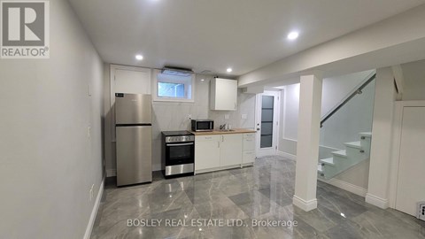 A modern kitchen with a stainless steel refrigerator and white cabinets.