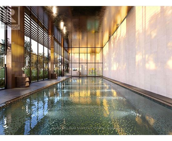 A long hallway with a pool in the middle and a wall on the right.