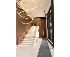 A staircase with a glass railing and a sign on the side.