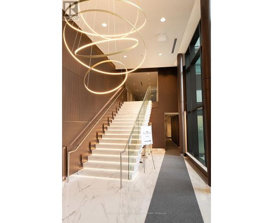 A staircase with a glass railing and a sign on the side.