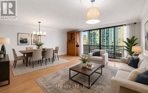 A well-lit living room with a dining area and a balcony overlooking the city.