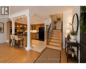 A well-lit, spacious kitchen and dining area with a bar stool and a table set for two.
