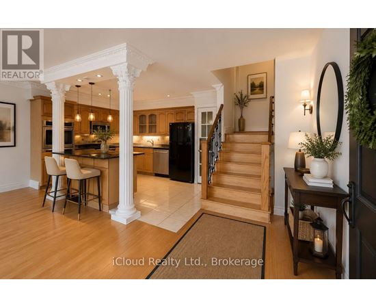 A well-lit, spacious kitchen and dining area with a bar stool and a table set for two.