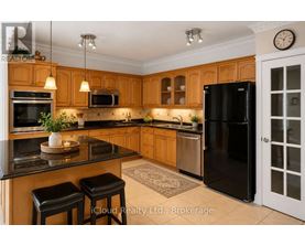 A kitchen with wooden cabinets and black appliances.