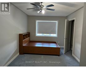 A bedroom with a bed, a window, and a ceiling fan.