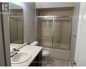 A bathroom with a sink, toilet, and shower.