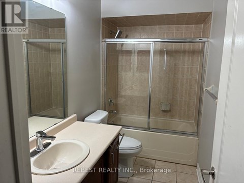 A bathroom with a sink, toilet, and shower.