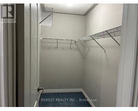 Empty walk in closet with shelves and a sign that says Rebest Realty Inc Brokerage.