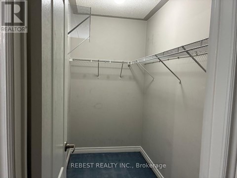 Empty walk in closet with shelves and a sign that says Rebest Realty Inc Brokerage.