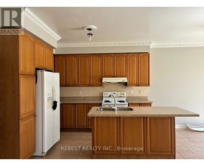 A kitchen with wooden cabinets and a white refrigerator.