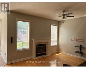 A room with a fireplace and a ceiling fan.